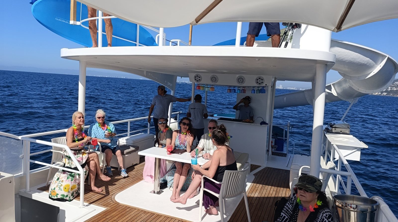 Grupo en la cubierta de un catamarán de 45 pies con tobogán en renta en Marina Vallarta, rumbo a las playas a las que sólo se llega en barco